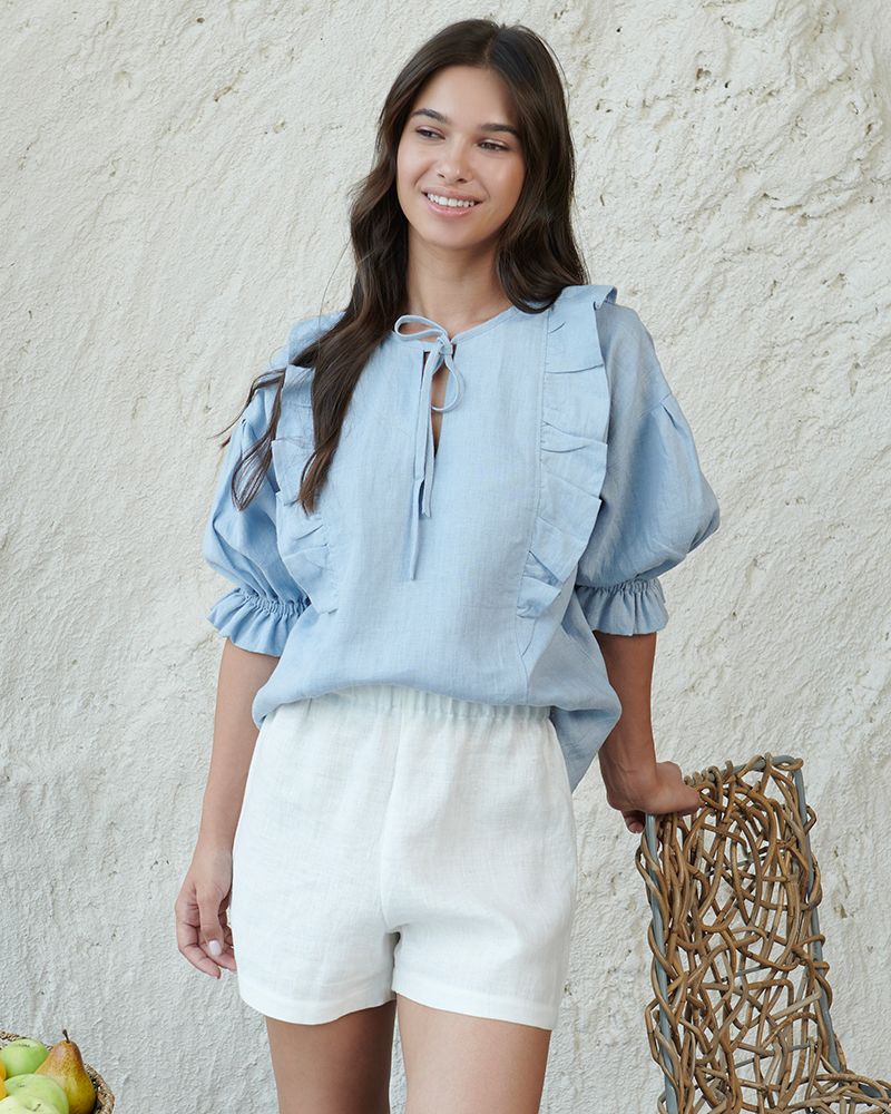 A lady in blur linen blouse and white linen shorts